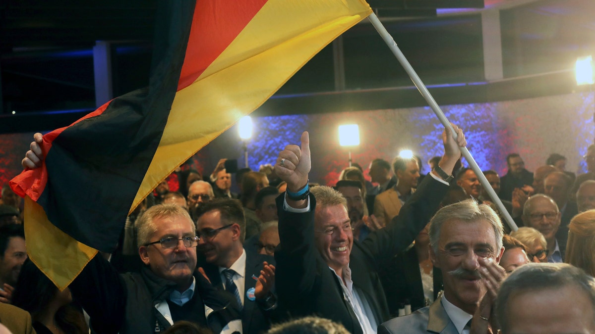 Supporters of the nationalist Alternative for Germany AfD celebrate after the state election in the German state of Hesse in Wiesbaden, western Germany, Sunday, Oct. 28, 2018. Exit polls show Chancellor Angela Merkel’s party leading with a significant drop in support for both her conservatives and their center-left partners in the national government. (Frank Rumpenhorst/dpa via AP)
