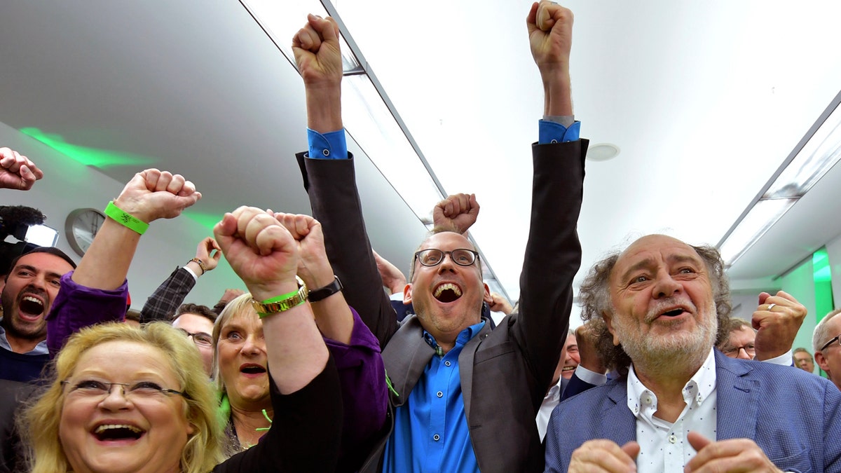 Supporters of the Green party celebrate after the state election in the German state of Hesse in Wiesbaden, western Germany, Sunday, Oct. 28, 2018. Exit polls show Chancellor Angela Merkel’s party leading with a significant drop in support for both her conservatives and their center-left partners in the national government. (Uwe Anspach/dpa via AP)