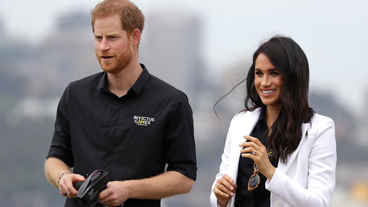 Britain's Prince Harry operates a remote control car with Meghan, Duchess of Sussex at the Invictus Games driving challenge on Cockatoo Island in Sydney, Australia, Saturday, Oct. 20, 2018. Prince Harry and his wife Meghan are on day five of their 16-day tour of Australia and the South Pacific. (AP Photo/Kirsty Wigglesworth)