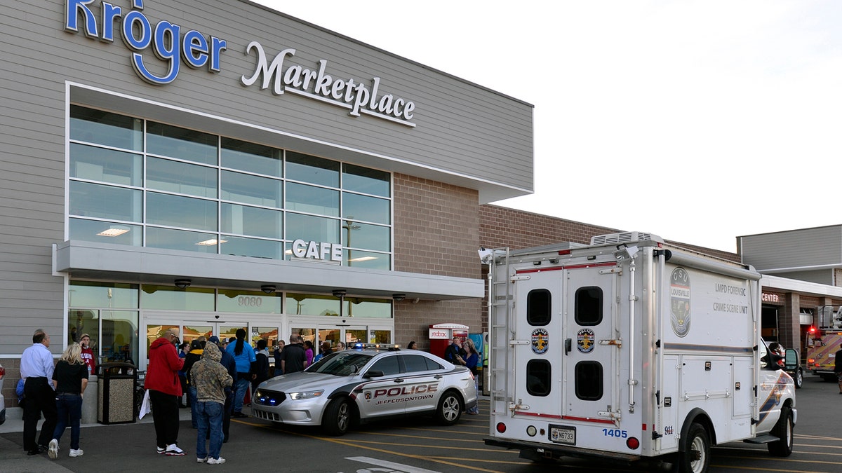 Employees wait outside the entrance of a Kroger grocery following a shooting that left two people dead and a suspect in custody, Wednesday, Oct. 24, 2018, in Jeffersontown, Ky. A man fatally shot another man inside a Kroger grocery store, shot and killed a woman in the parking lot, and then exchanged fire with an armed bystander who intervened before he fled the scene on the outskirts of Louisville, Kentucky, on Wednesday, police said. He was captured shortly afterward. (AP Photo/Timothy D. Easley)