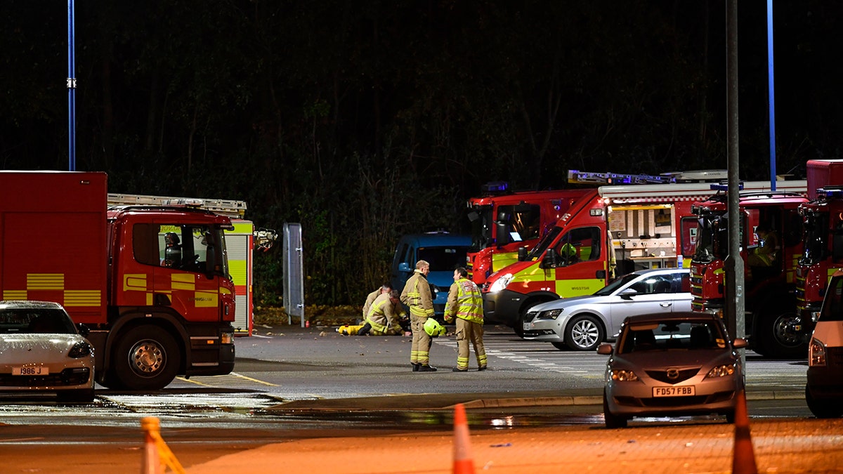 Emergency personnel stand outside the King Power Stadium in Leicester, England after a helicopter belonging to Leicester City Football Club owner Vichai Srivaddhanaprabha crashed in a parking lot. (Joe Giddens/PA via AP)