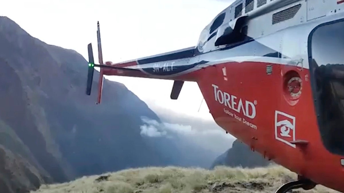 Image from video provided by SIMRIK AIR showing a helicopter that landed close to a storm site after searching for missing mountaineers on the Gurja Himal mountain, in Nepal, Saturday. (SIMRIK AIR via AP)