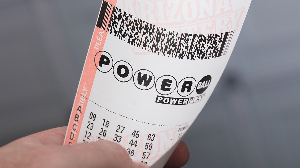Kingman, USA - January 20, 2016: A photo of a man holding a Powerball lottery ticket in Kingman, Arizona.