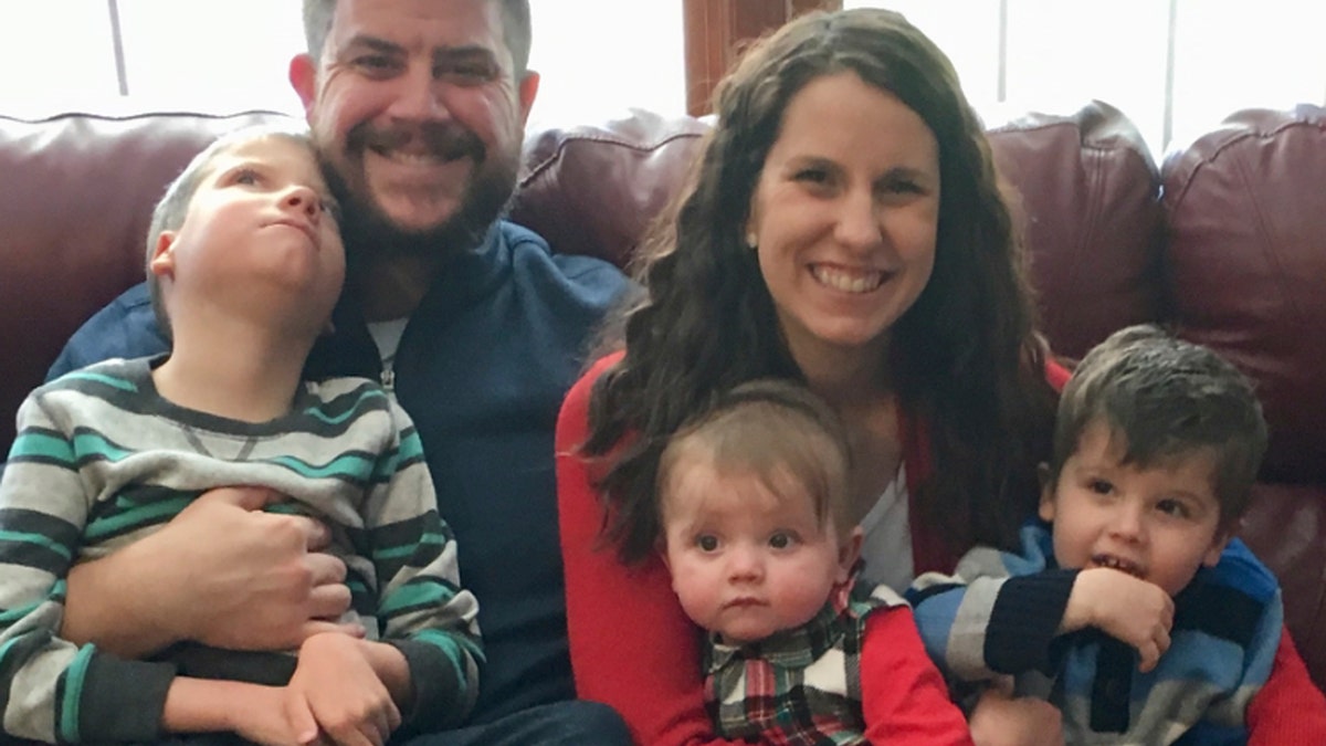 In this Dec. 10, 2017 photo provided by the family, Jon and Kari Kilquist sit with their children, from left, Will, who was born with a list of mysterious symptoms, Emmy and Owen at their home in Murphysboro, Ill. 