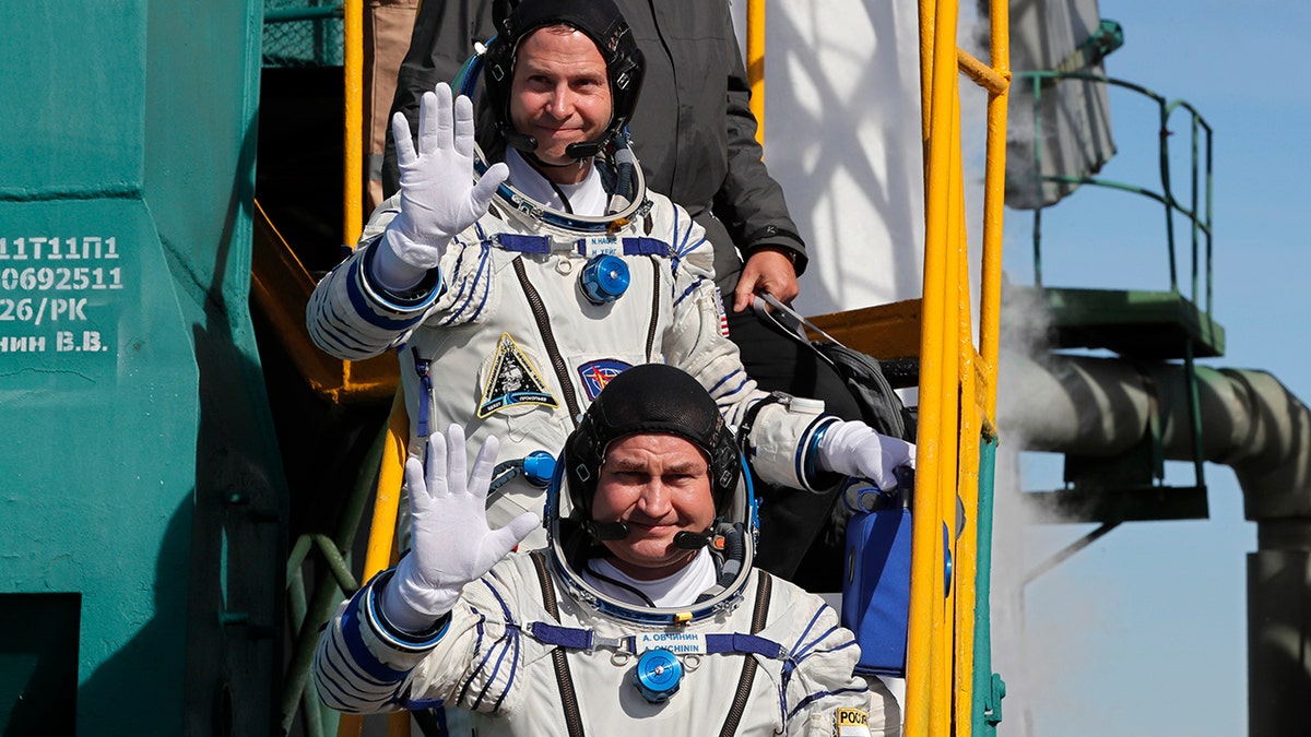 U.S. astronaut Nick Hague, top, and Russian cosmonaut Alexey Ovchinin, crew members of the mission to the International Space Station wave as they board the rocket prior to the launch of Soyuz-FG rocket at the Russian leased Baikonur cosmodrome, Kazakhstan, Thursday, Oct. 11, 2018.