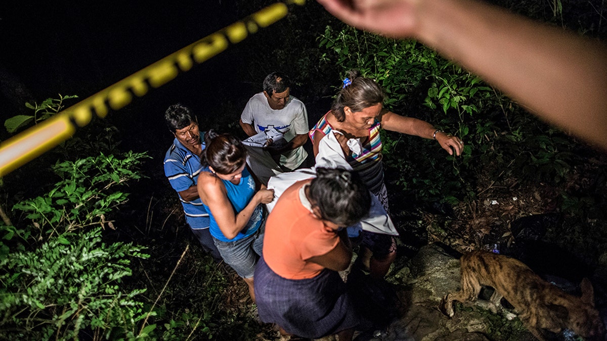 Relatives of a Mara Salvatrucha gang member retrieve his body from a steep gully after he was shot dead in a confrontation with police, in Olocuilta, El Salvador. Two bodies were found at the bottom of the gully following a shootout that began near an old cattle stable, which gang members had turned into a shooting range. El Salvador’s homicide rate was 60 per 100,000 inhabitants last year, down from a grisly record of 102 homicides per 100,000 inhabitants in 2015 but still among the highest in the world. (AP Photo/Manu Brabo, File)