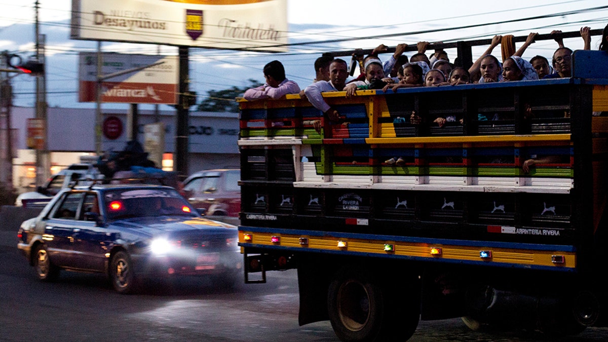 Commuters ride in the back of a pickup as night falls in San Miguel, El Salvador. It’s a small country both geographically and by population, home to 6.5 million inhabitants. The International Organization for Migration estimates that another 1.35 million Salvadorans live in the United States. (AP Photo/Rebecca Blackwell, File)