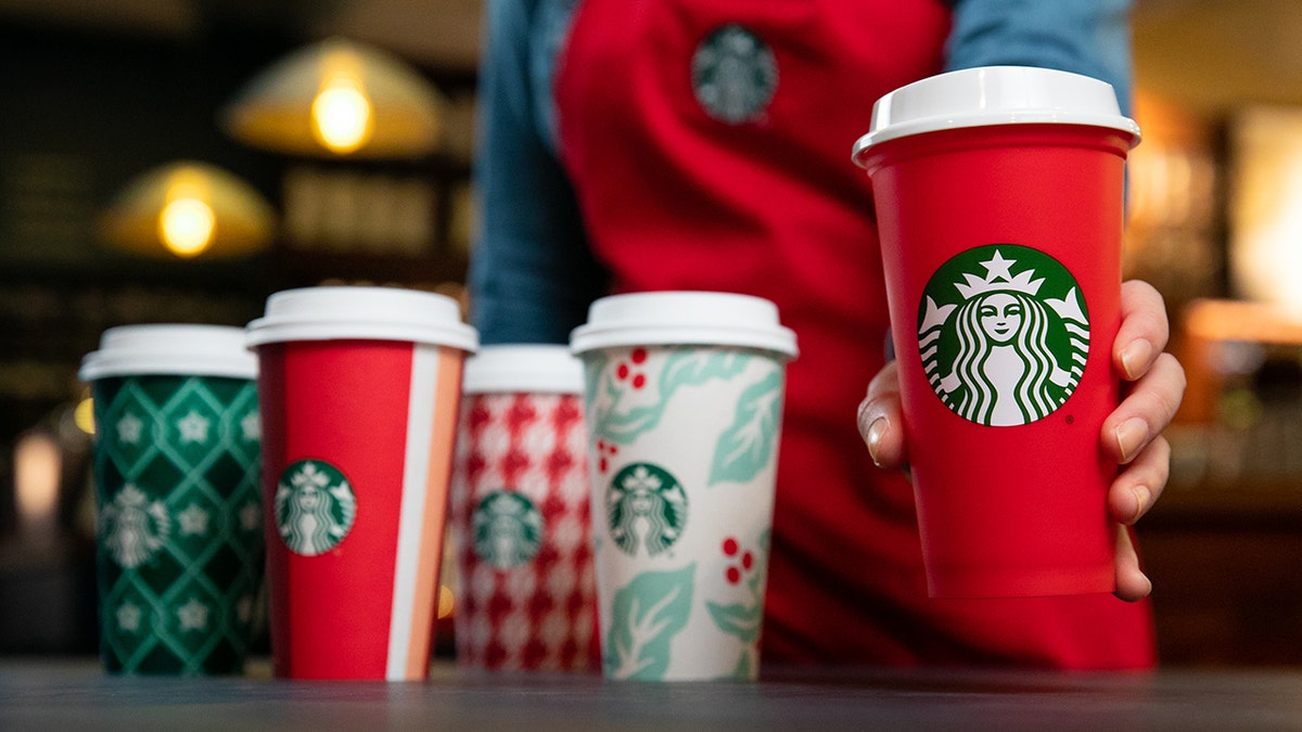 The new cups, along with a limited edition reusable cup (right), will be available starting Nov. 2.