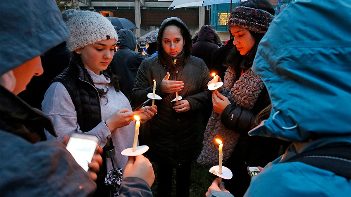 Holding candles, a group of girls wait for the start of a memorial vigil at the intersection of Murray Ave. and Forbes Ave. in the Squirrel Hill section of Pittsburgh, for the victims of the shooting at the Tree of Life Synagogue where a shooter opened fire, killing multiple people and wounding others, including sevearl police officers.