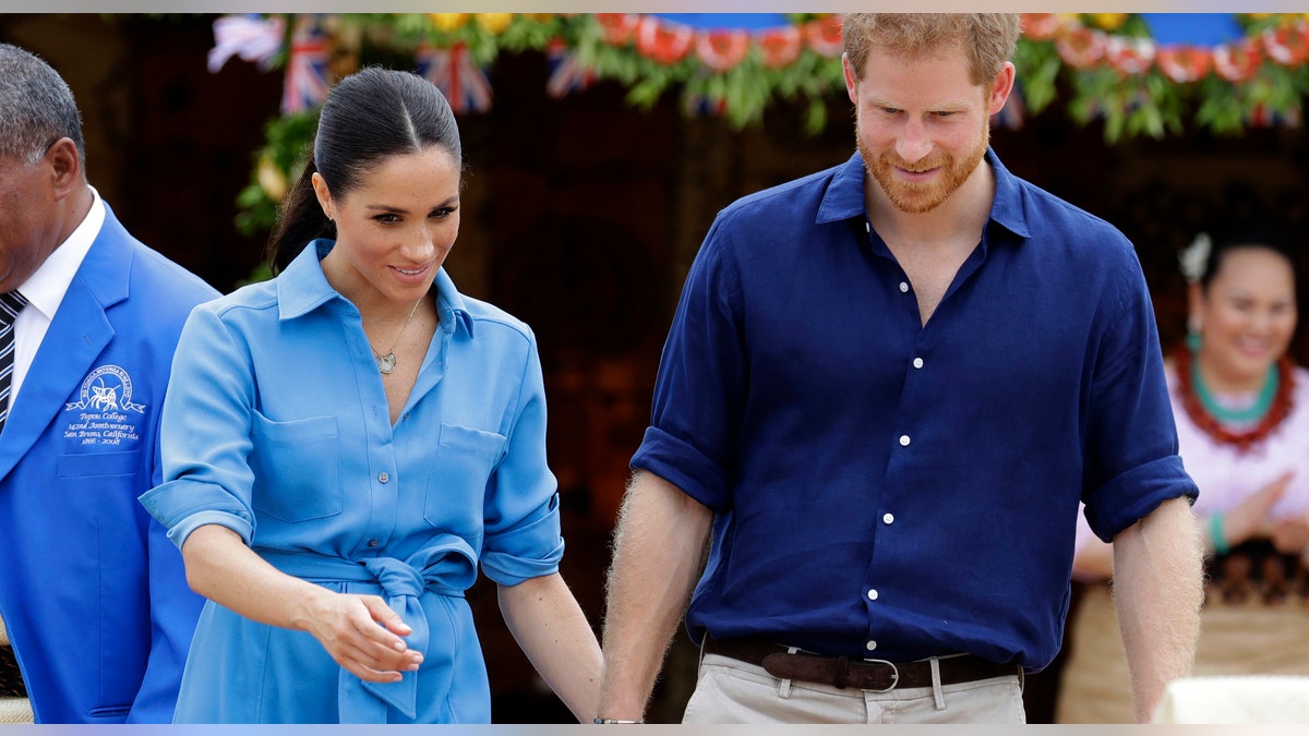 Britain's Prince Harry and Meghan, Duchess of Sussex smile during a visit to Tupou College in Tonga, Friday, Oct. 26, 2018.