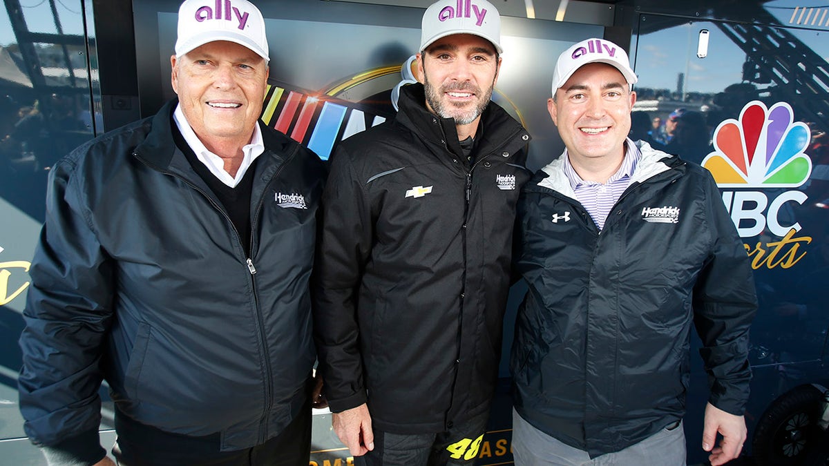 Jimmie Johnson, center, poses with owner Rick Hendrick, left, and Ally Financial CEO Jeffery Brown, right.