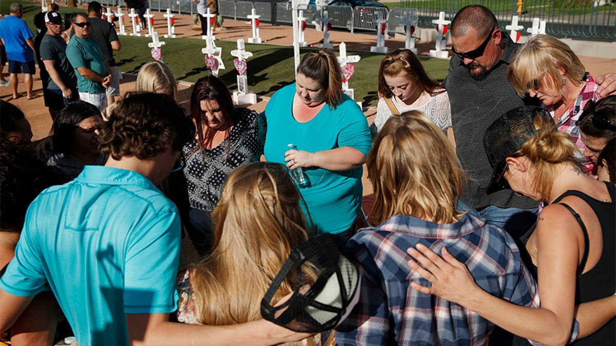 People pray at a makeshift memorial for victims of the Las Vegas shooting Sunday in Las Vegas.