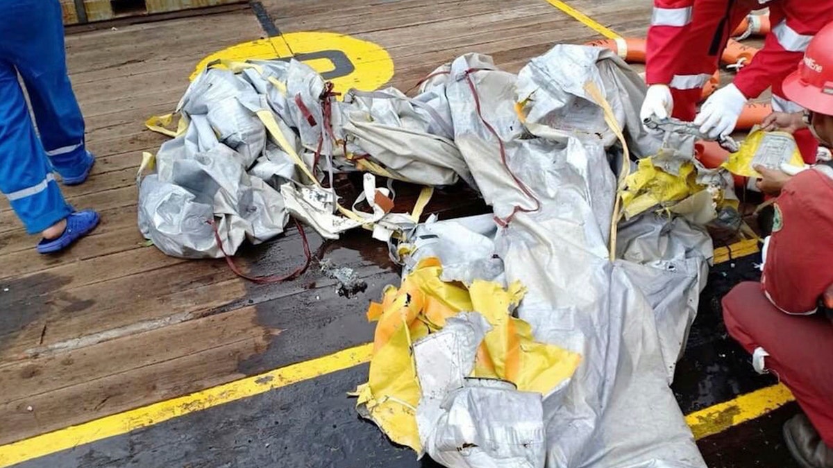 In this photo released by Indonesian Disaster Mitigation Agency (BNPB) rescuers inspect debris believed to be from Lion Air passenger jet that crashed off West Java on Monday, Oct. 29, 2018.