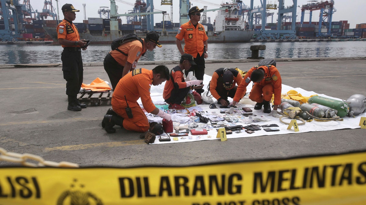 Rescuers examine personal belongings of passengers of a crashed Lion Air plane recovered from the waters near where the passenger jet is believed to have crashed, at Tanjung Priok Port in Jakarta, Indonesia, Tuesday, Oct. 30, 2018.