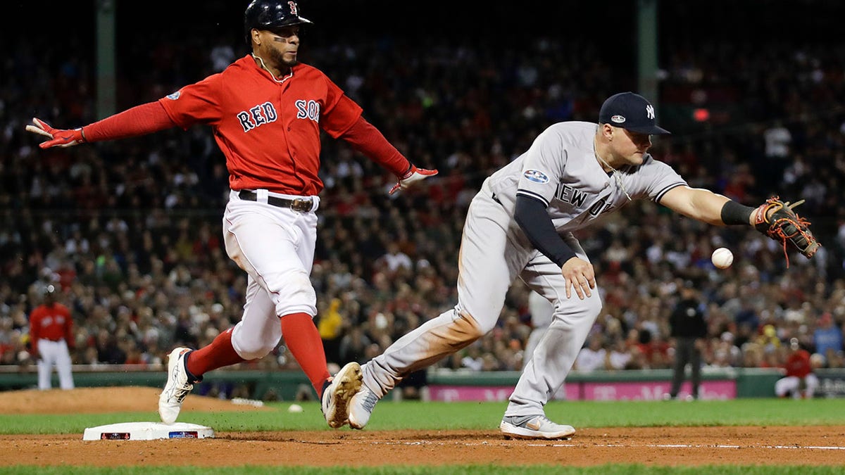 New York Yankees first baseman Luke Voit, right, fails to hang on to the throw after a single by Boston Red Sox's Xander Bogaerts during the fifth inning of Game 1 of the American League Division Series, in Boston, Oct. 5, 2018.