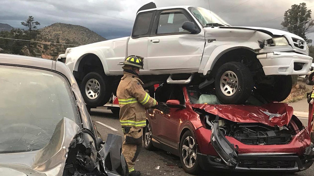 In this Sunday, Oct. 7, 2018 photo provided by the Prescott Fire Department, firefighters work the scene of an accident in Prescott, Ariz. (Ralph Lucas/Prescott Fire Department via AP)