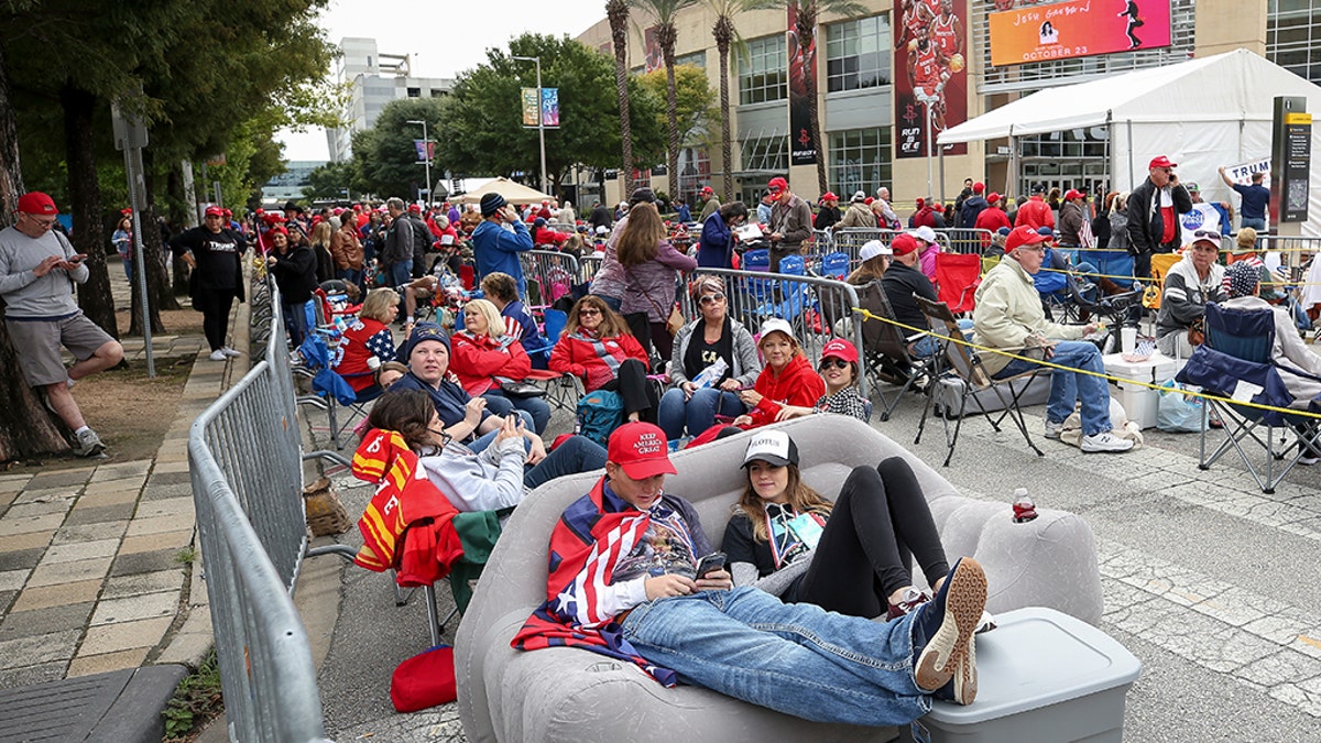 Kersten Buck, 25, and her fiance Clayton Dupree, 25, sit on an inflatable couch as they wait for a President Trump rally for Sen. Ted Cruz at the Toyota Center on Monday in Houston. (Godofredo A. Vasquez/Houston Chronicle via AP)