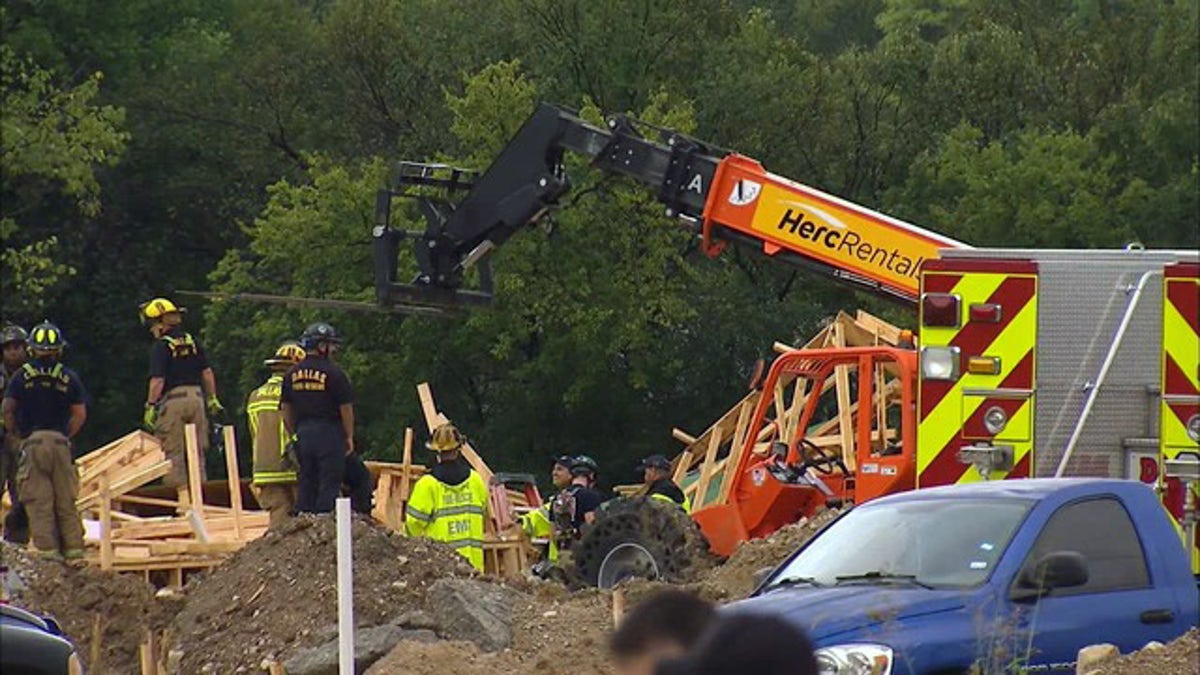 Rescue personnel examining the scene where a townhouse under construction collapsed in West Dallas.
