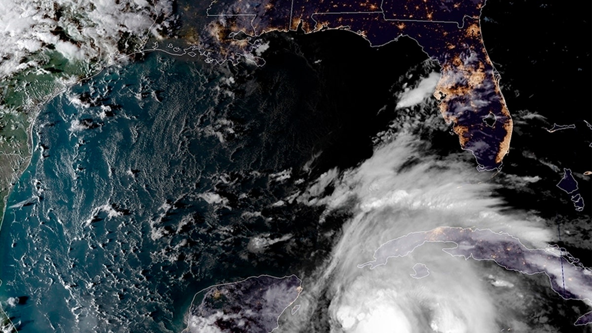 This satellite image provided by the National Oceanic and Atmospheric Administration shows a view of Tropical Storm Michael, lower right, churning as it heads toward the Florida Panhandle.