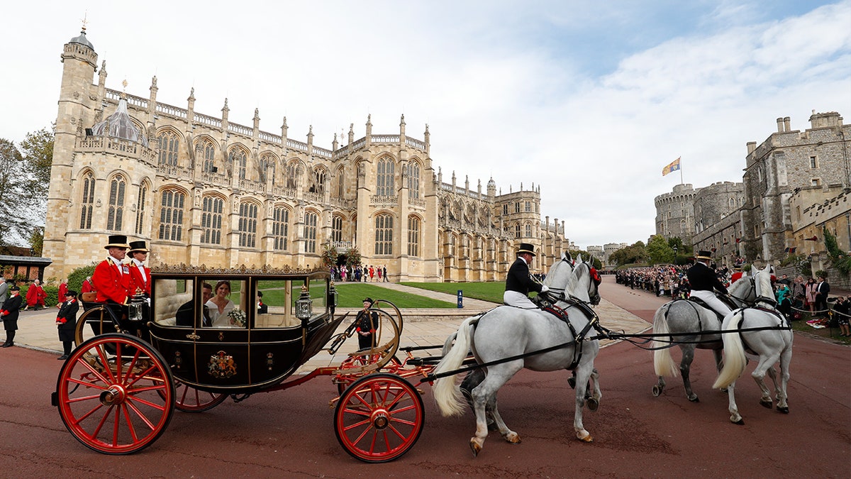 Britain's Princess Eugenie of York, right, and her husband Jack Brooksban travel in the Scottish State Coach following their wedding at St George’s Chapel, Windsor Castle, near London, England, Friday Oct. 12, 2018. (Adrian Dennis/Pool via AP)