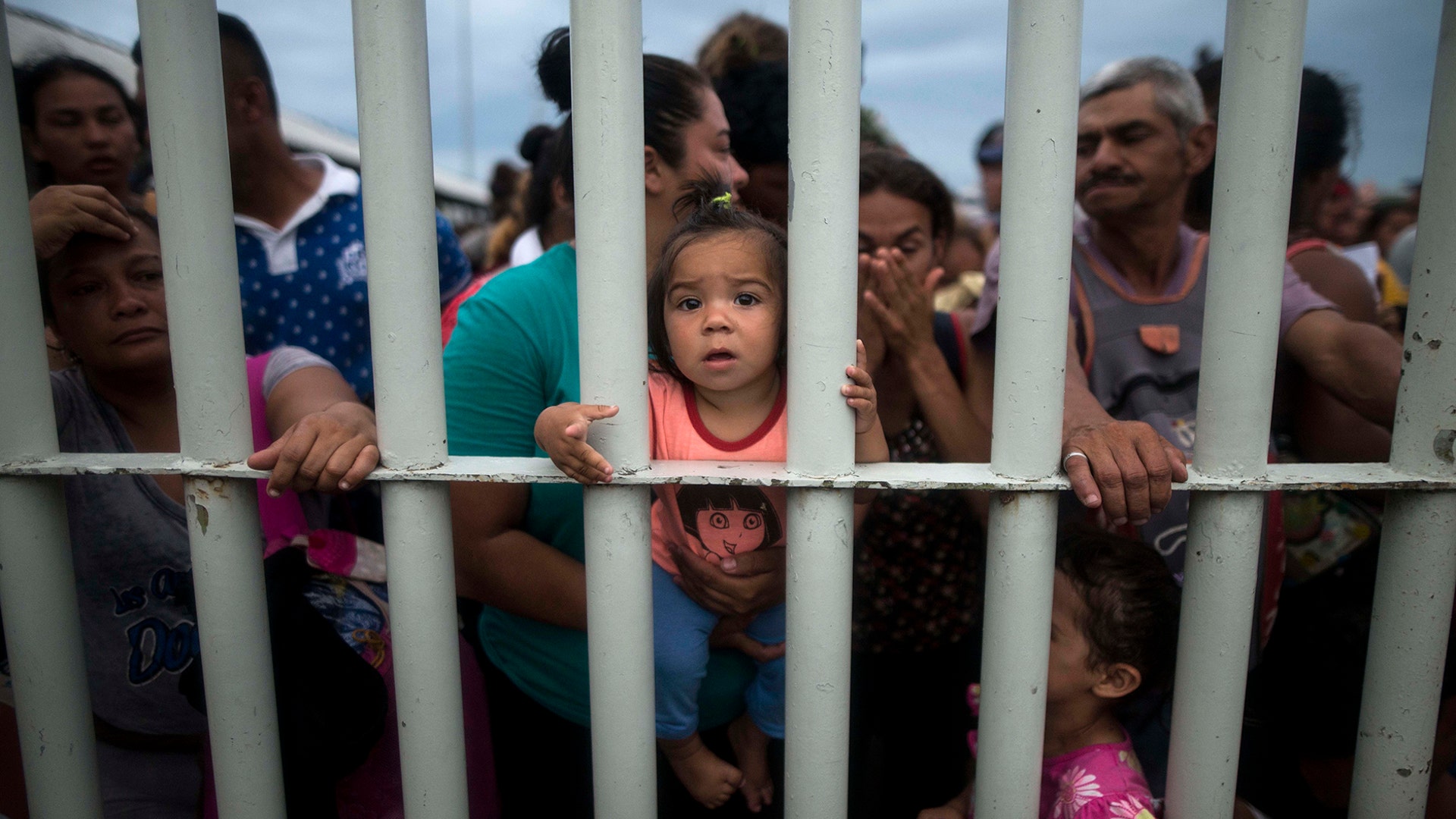 Migrants bound for the United States-Mexico border wait on a bridge that stretches over the Suchiate River, connecting Guatemala and Mexico, in Tecun Uman, Guatemala, on Oct. 19, 2018.