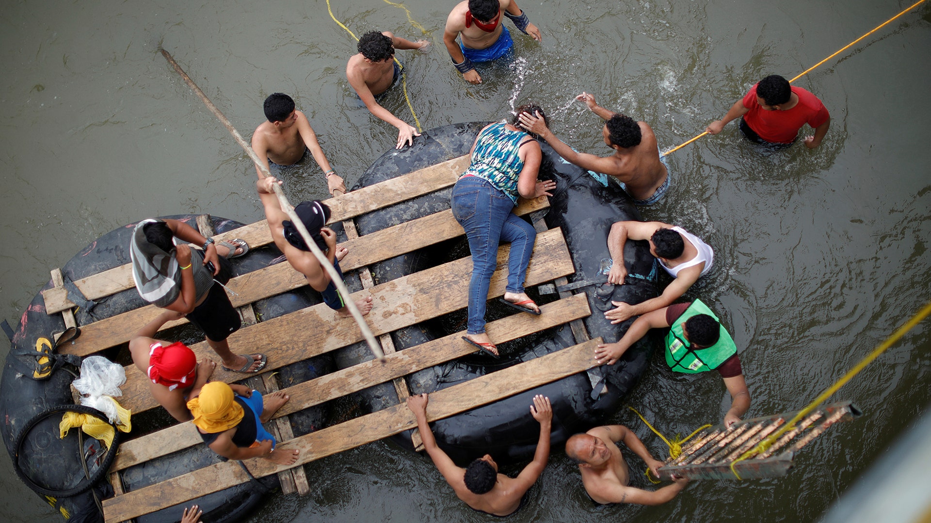 Central American migrants trying to reach the United States use a raft after climbing down from a bridge that connects Mexico and Guatemala in Ciudad Hidalgo, Mexico, on Oct. 20, 2018.