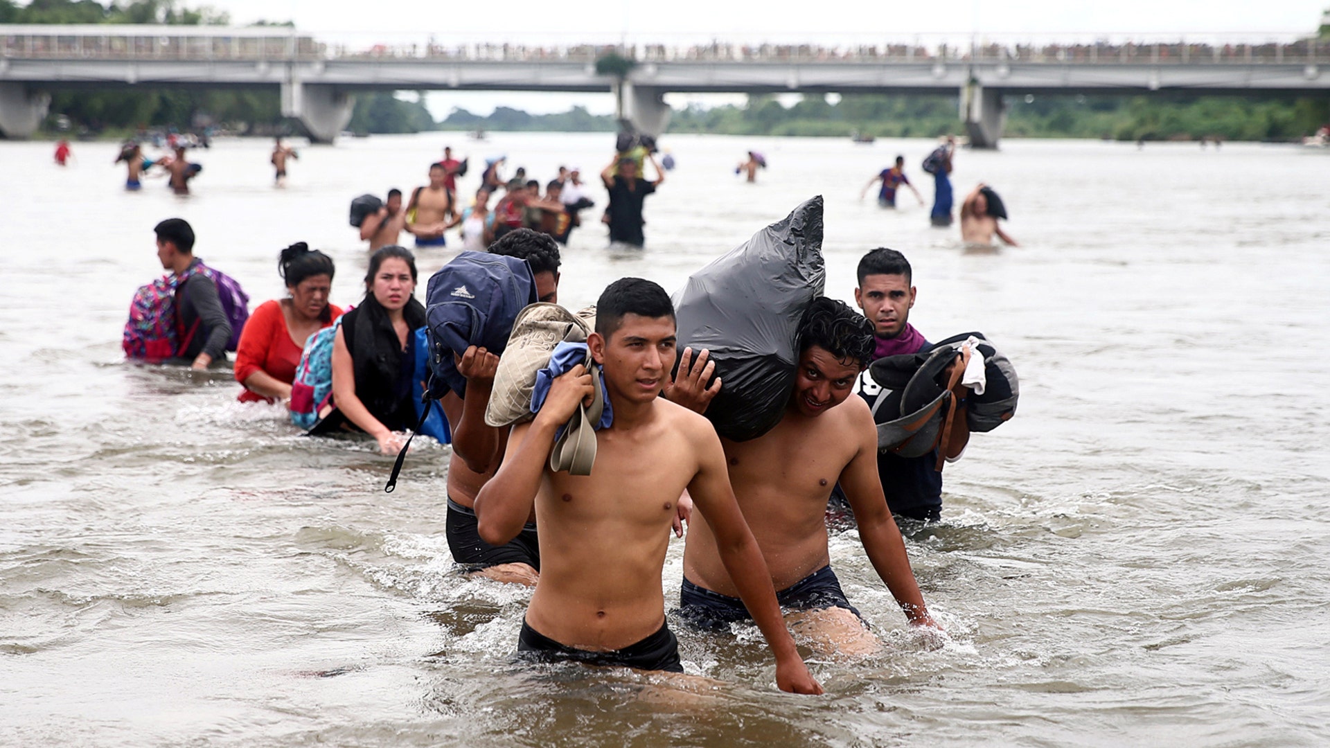 Central American migrants, part of a caravan trying to reach the United States cross the Suchiate River in Ciudad Hidalgo, Mexico, on Oct. 20, 2018.