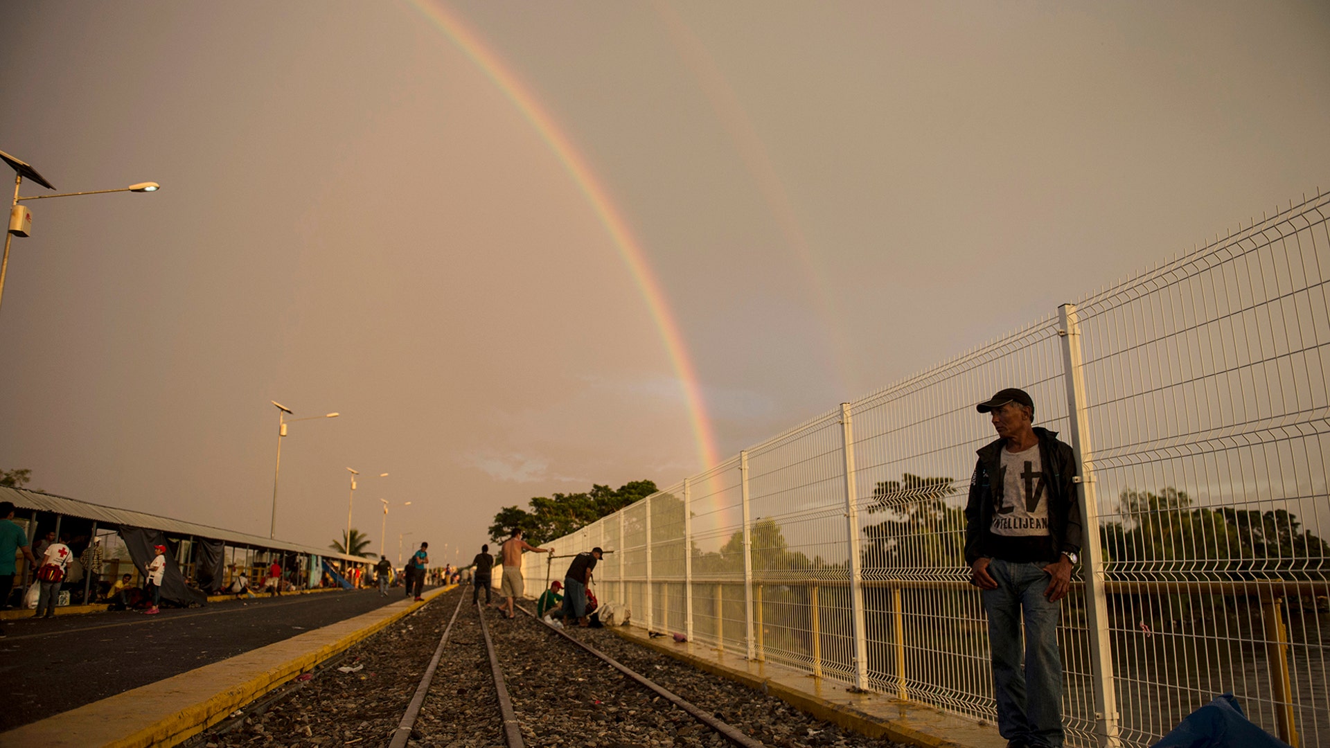 A Honduran migrant stands on a bridge that stretches over the Suchiate River connecting Guatemala and Mexico, in Tecun Uman, Guatemala, on Oct. 21, 2018.