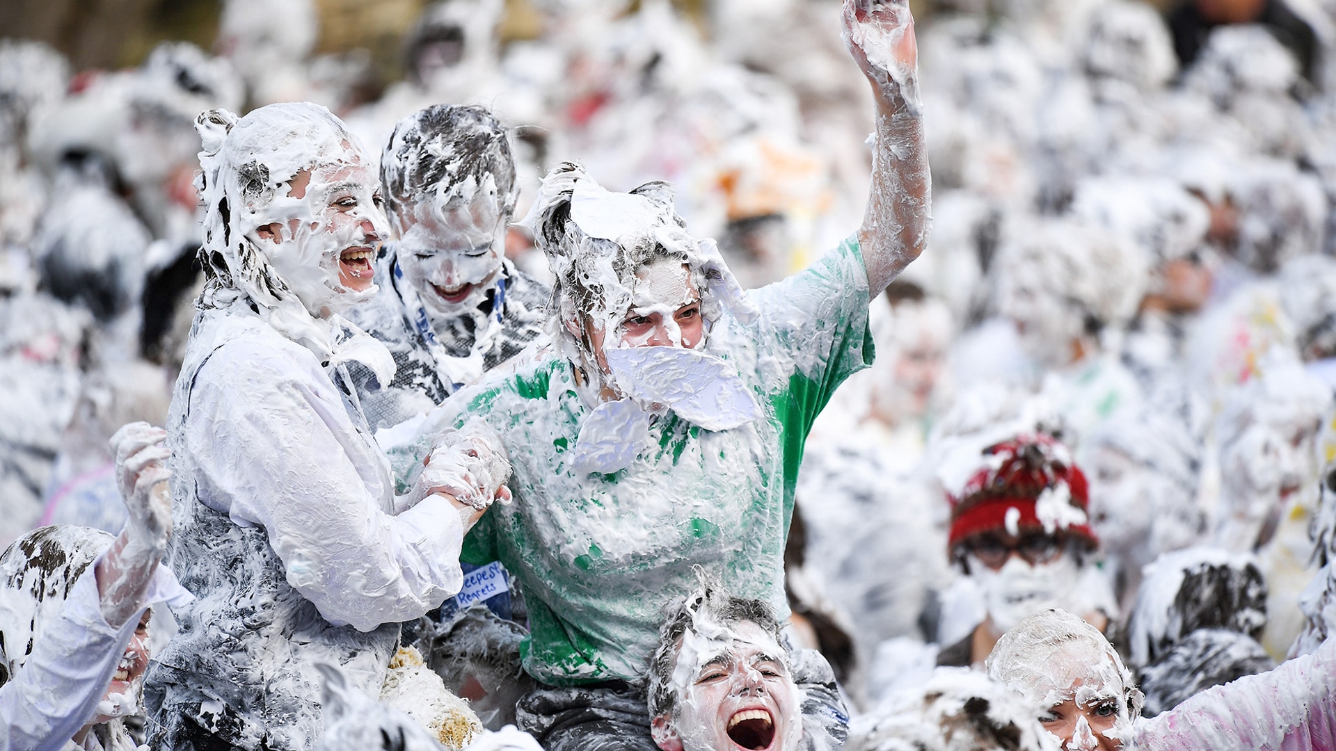 Students from St. Andrews University indulge in a tradition of covering themselves with foam to honor the 'academic family' on the lower college lawn on in St Andrews, Scotland, Oct. 22, 2018. 