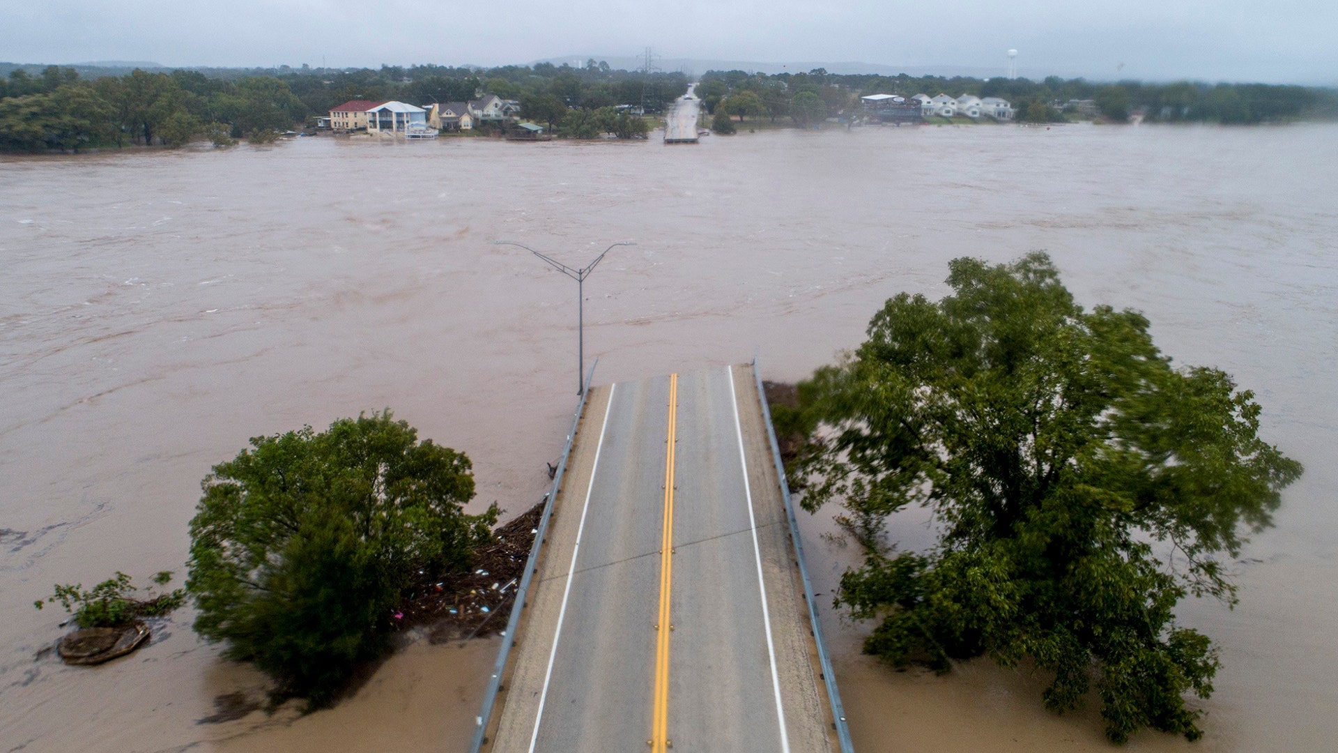 The Llano River flows between the washed out Ranch Road 2900 bridge in Kingsland, Texas, Oct. 16, 2018.