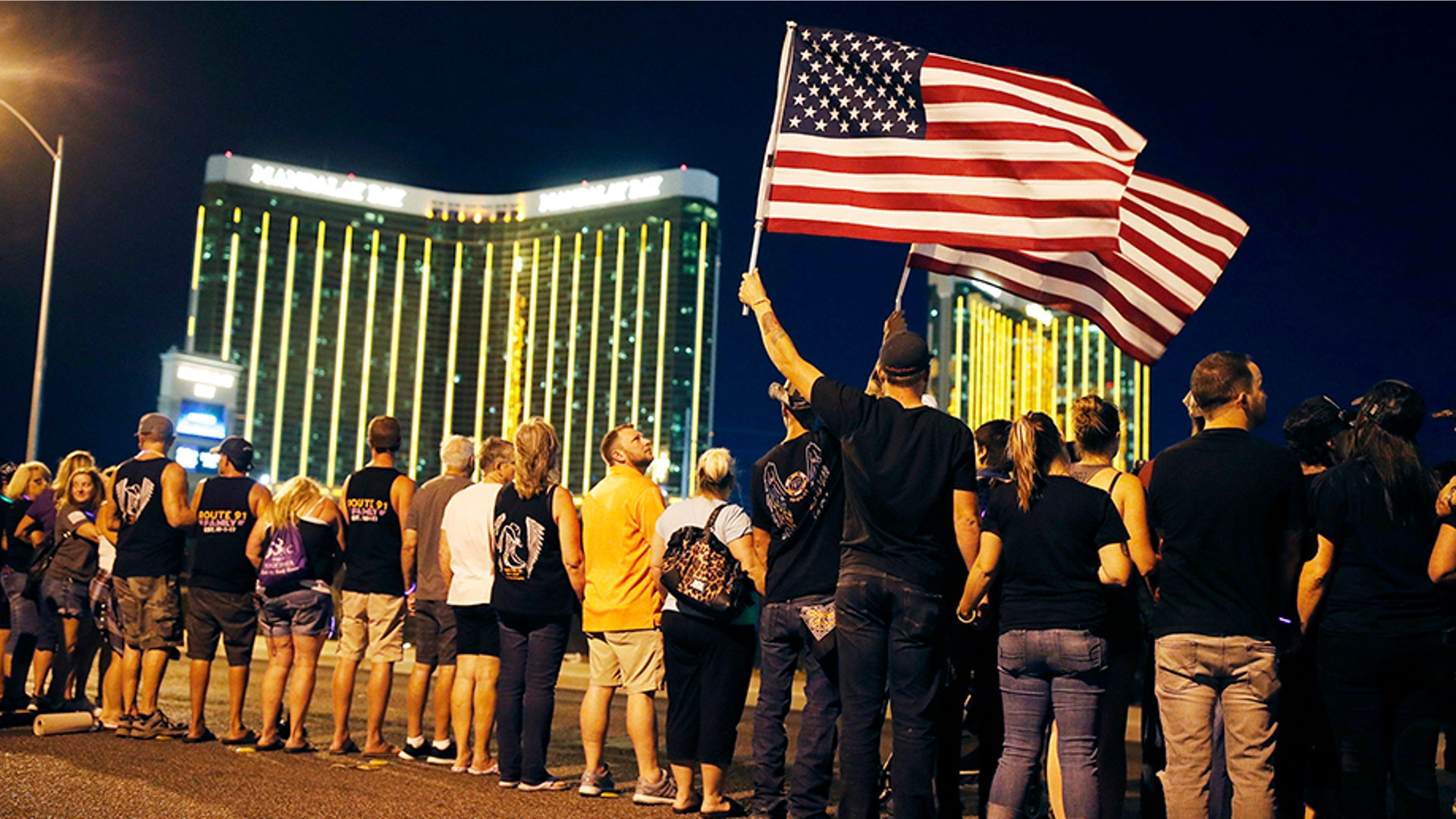 People form a human chain around the shuttered site of a country music festival where a gunman opened fire on the first anniversary of the mass shooting, in Las Vegas, Oct. 1, 2018.