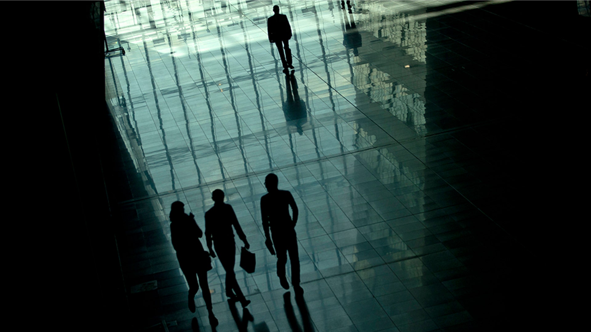People walk along the main hall of the NATO headquarters during the second day of a meeting of the North Atlantic Council at a gathering of NATO defence ministers in Brussels, Oct. 4, 2018.