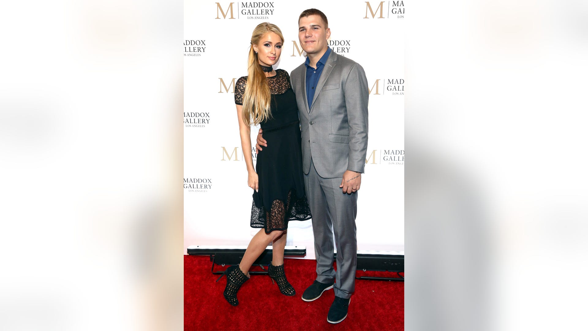 Paris Hilton played it coy alongside fiancé Chris Zylka at the VIP opening of Maddox Gallery LA in West Hollywood, Calif. on October 11, 2018.