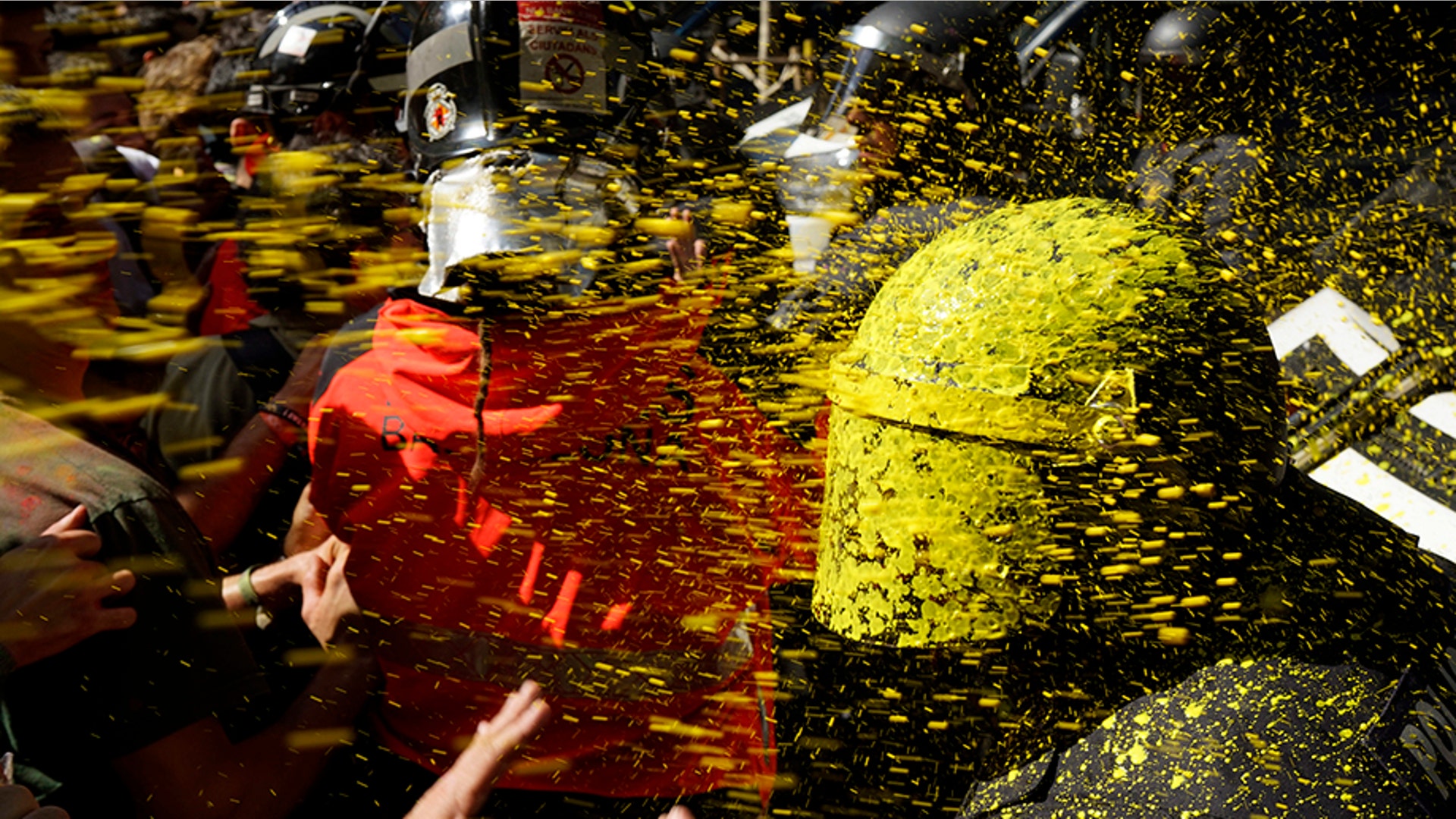 Pro independence demonstrators throw paint at Catalan police officers during clashes in Barcelona, Spain, Sept. 29, 2018.