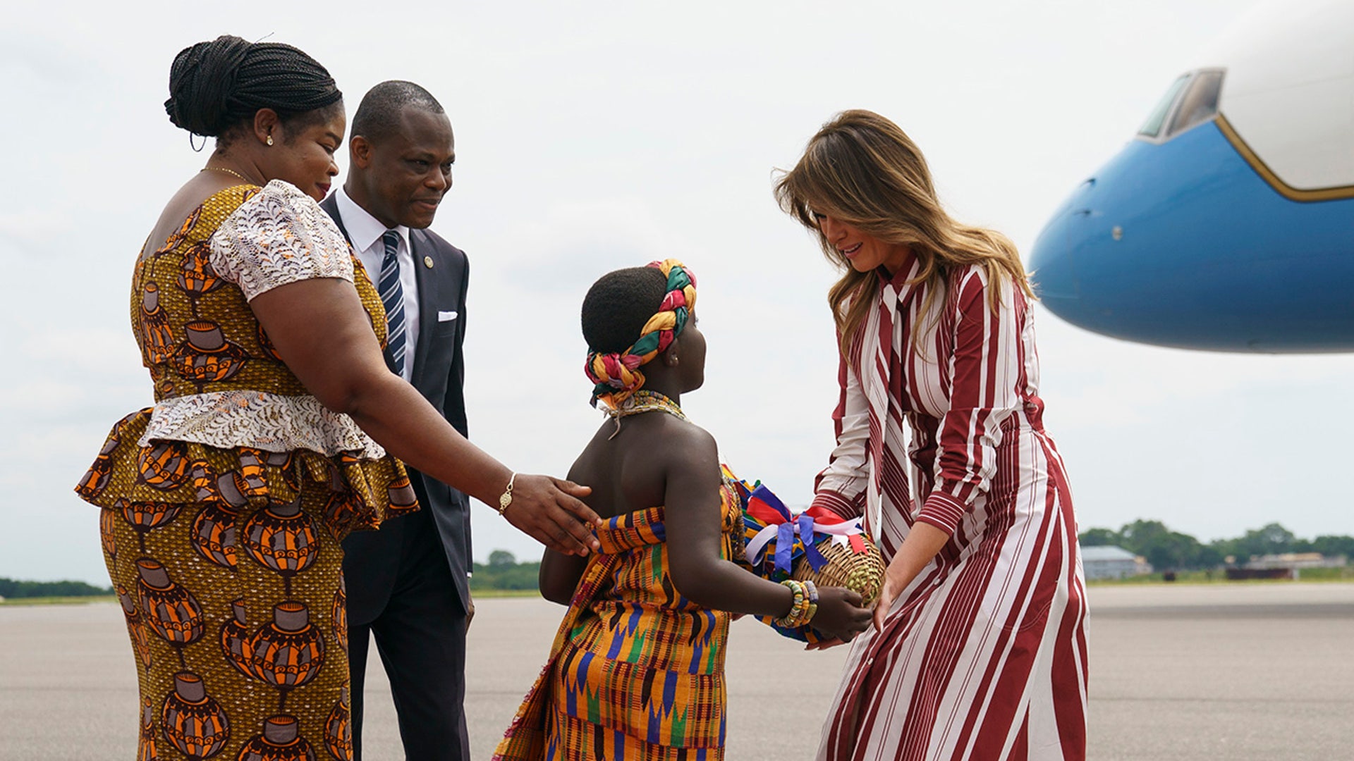 First lady Melania Trump accepts flowers from flower girl Lillian Naa Adai Sai, 8, as she receives flowers as she arrives at Kotoka International Airport in Accra, Ghana, Tuesday, Oct. 2, 2018.  (AP Photo/Carolyn Kaster)