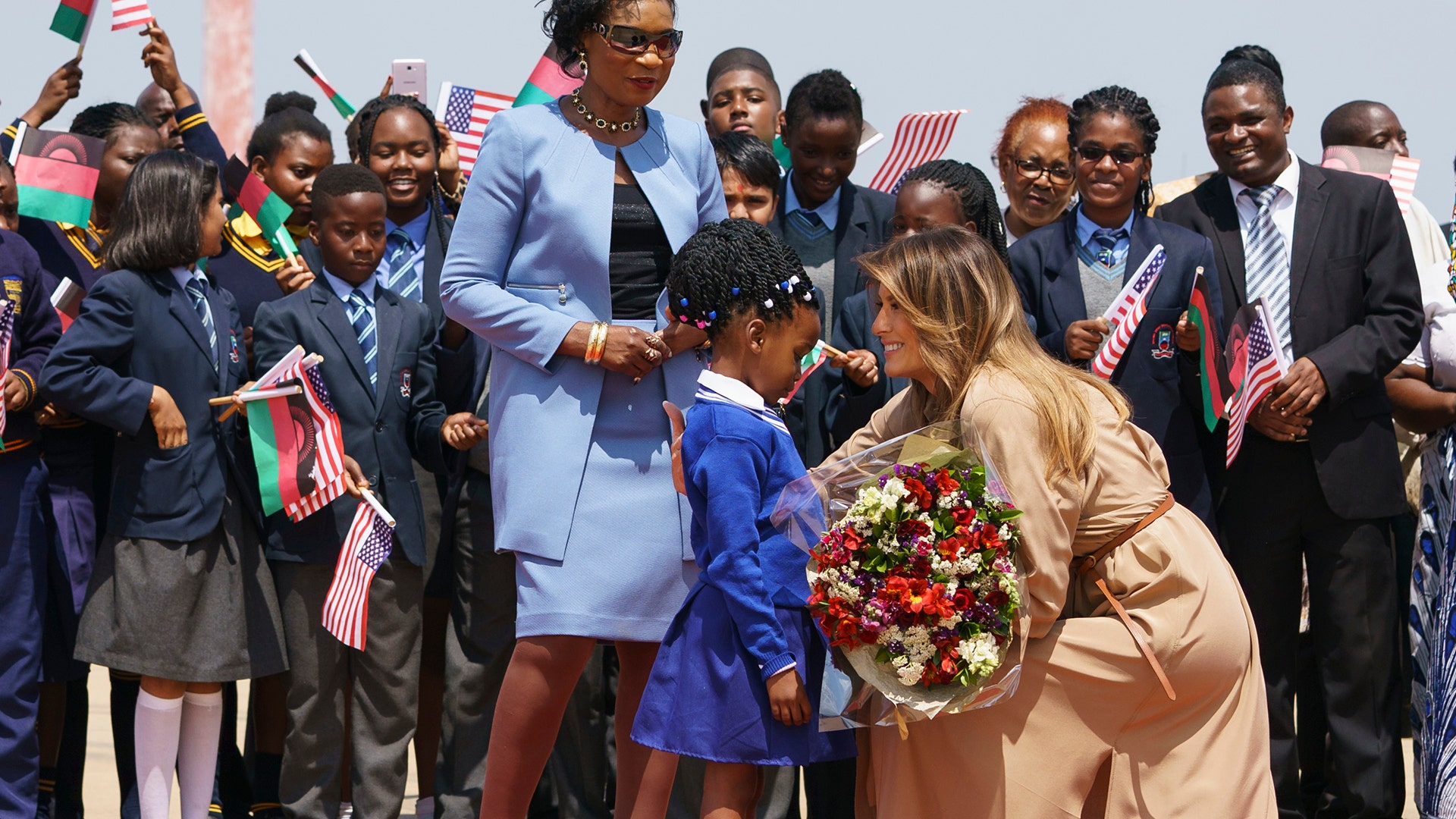 First lady Melania Trump is greeted by Malawi first lady Gertrude Maseko and a flower girl as she arrives at Lilongwe International Airport, in Lumbadzi, Malawi, Thursday, Oct. 4, 2018. (AP Photo/Carolyn Kaster)