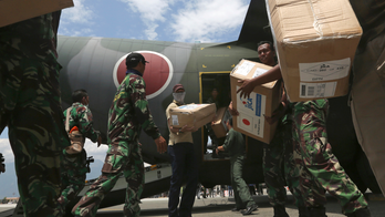 The Latest: Indonesia mulls making quake areas mass graves