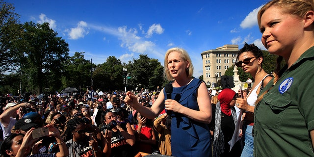 Sen. Kirsten Gillibrand, D-N.Y., with actress and comedian Amy Schumer, right, speaks at a rally against Supreme Court nominee Brett Kavanaugh at the Supreme Court in Washington, Thursday, Oct. 4, 2018. (AP Photo/Manuel Balce Ceneta)