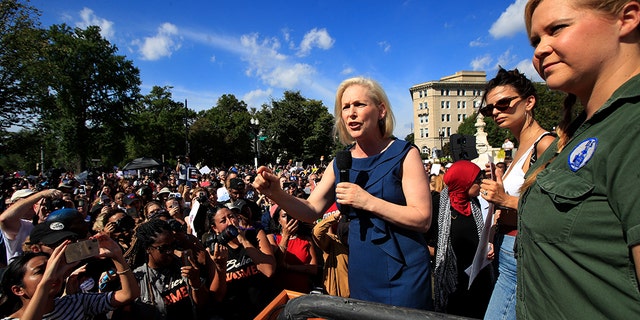 Sen. Kirsten Gillibrand, D-N.Y., with actress and comedian Amy Schumer, right, speaks at a rally against Supreme Court nominee Brett Kavanaugh at the Supreme Court in Washington, Thursday, Oct. 4, 2018. (AP Photo/Manuel Balce Ceneta)