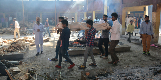 The body of a victim of Friday's train accident is carried in for cremation in Amritsar, India, Saturday, Oct. 20, 2018. A speeding train ran over a crowd watching fireworks during a religious festival in northern India on Friday evening, killing more than 50 people and injuring dozens more, police said.