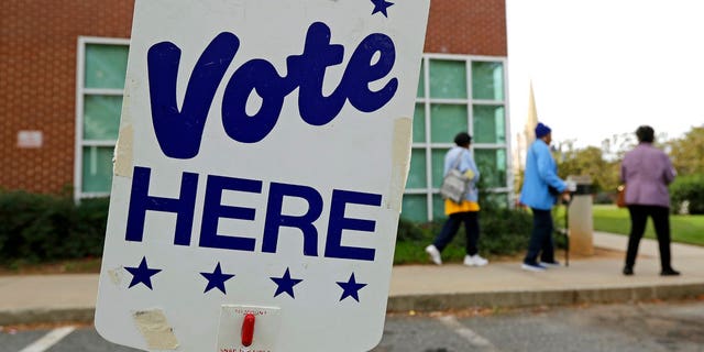 People arrive for early voting at a polling place in Charlotte, N.C., Tuesday, Oct. 23, 2018. (AP Photo/Chuck Burton)