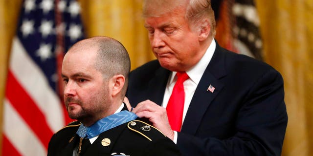 President Donald Trump awards the Medal of Honor to former Army Staff Sgt. Ronald J. Shurer II for actions in Afghanistan, in the East Room of the White House, Monday, Oct. 1, 2018, in Washington. (AP Photo/Pablo Martinez Monsivais)
