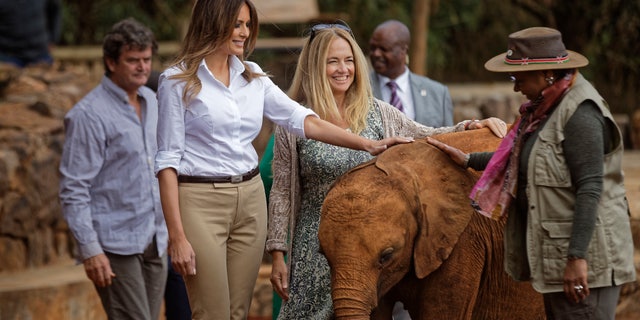 First lady Melania Trump pets a baby elephant, accompanied by CEO Angela Sheldrick (center) and Kenya's first lady Margaret Kenyatta (right) at the David Sheldrick Wildlife Trust elephant orphanage in Nairobi, Kenya. Trump took part in a baby elephant feeding on Friday as she visited a national park in Kenya to highlight conservation efforts. (AP Photo/Ben Curtis, Pool)