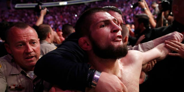 FILE: Khabib Nurmagomedov is held back outside of the cage after fighting Conor McGregor. 