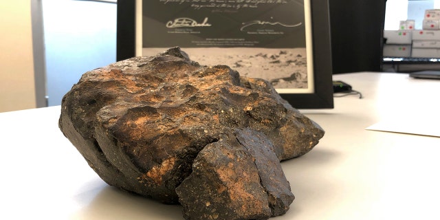 A 12-pound lunar meteorite discovered in Northwest Africa in 2017 rests on a table, in Amherst, N.H.