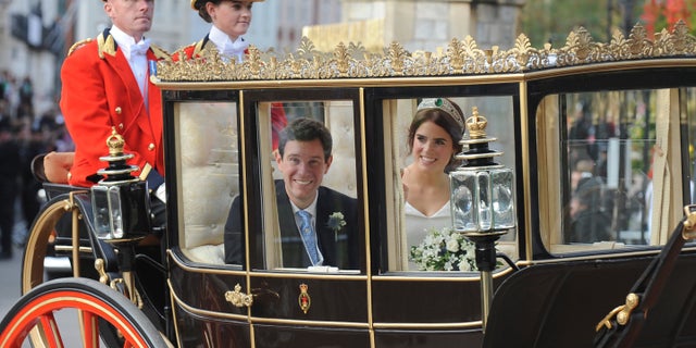 Princess Eugenie of York, right, and Jack Brooksbank travel from St George's Chapel to Windsor Castle after their wedding at St George's Chapel, Windsor Castle, near London, England, Friday, Oct 12, 2018. (AP Photo/Rui Vieira)