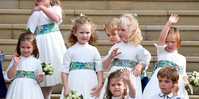 Bridesmaids and page boys, including Prince George, center, and Princess Charlotte, left, wave as they leave after the wedding ceremony of Princess Eugenie of York and Jack Brooksbank. (AP)