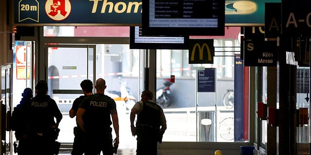 Police forces stand at the Cologne, western Germany, main station Monday, Oct. 15, 2018, after they have closed parts of the station because of a hostage situation.