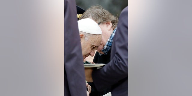 Pope Francis talks with director Michael Moore during his weekly general audience, in St.Peter's Square, at the Vatican, Wednesday, Oct. 17, 2018.