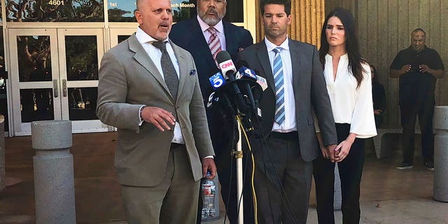 Reality show doctor Grant Robicheaux, second from right, and his girlfriend, Cerissa Riley, listen as Robicheaux's attorney, Philip Cohen, left, speaks outside court in Newport Beach, California.